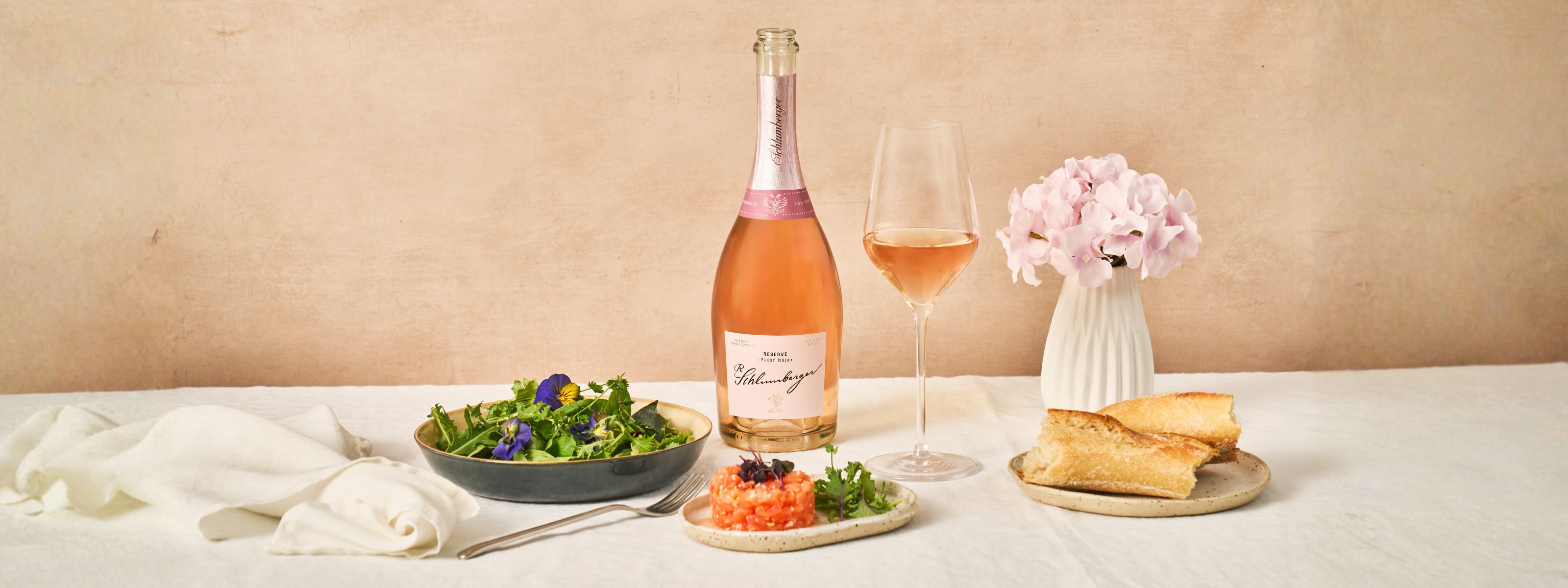 Pinot Noir Flasche und Glas sowie Lachstartar sind am Esstisch