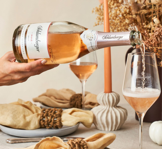 Rosé Brut wird in ein Glas am Esstisch eingeschenkt