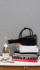 Handtasche auf einen Spel mit Büchern und eine Flasche Schlumberger Sparkling